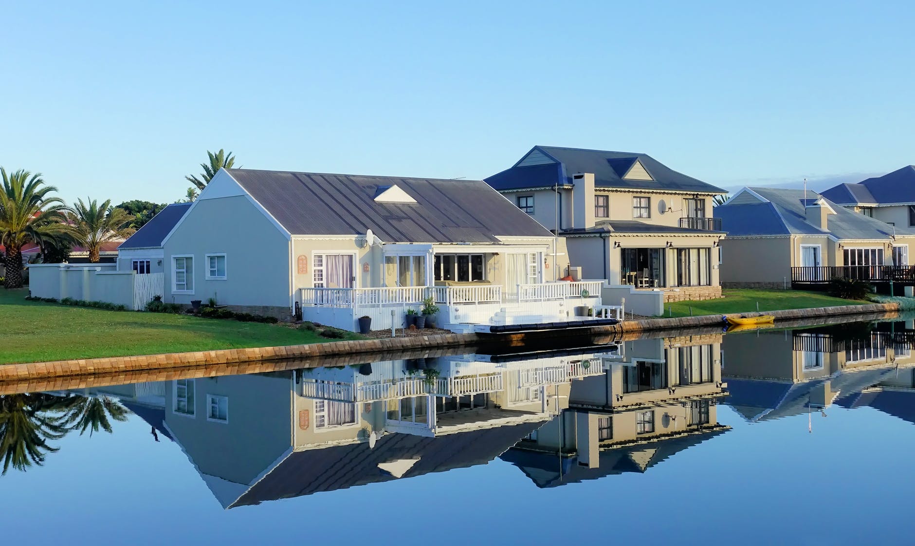 white single story houses beside body of water