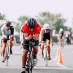 unrecognizable cyclists riding bikes on road during race