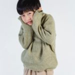 cute shy ethnic boy in sweater