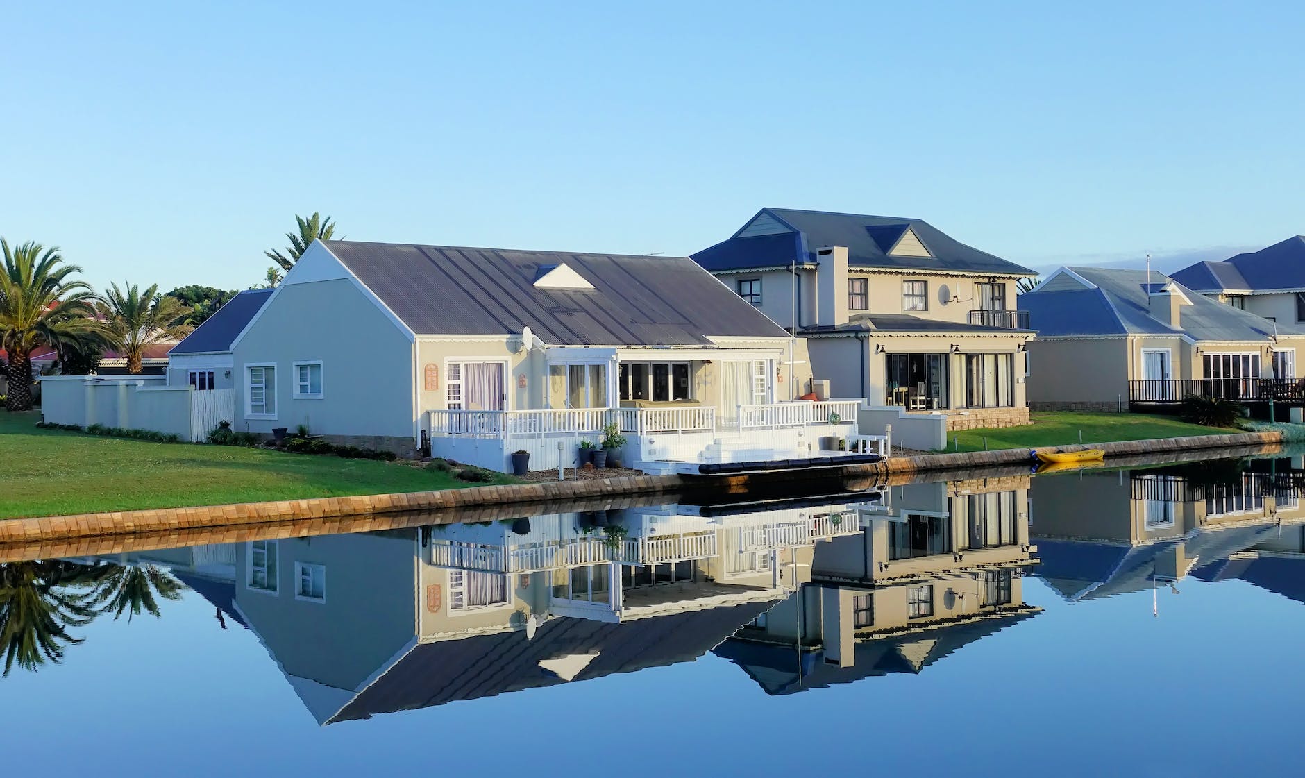 white single story houses beside body of water