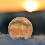frozen soap bubble against sky during sunset