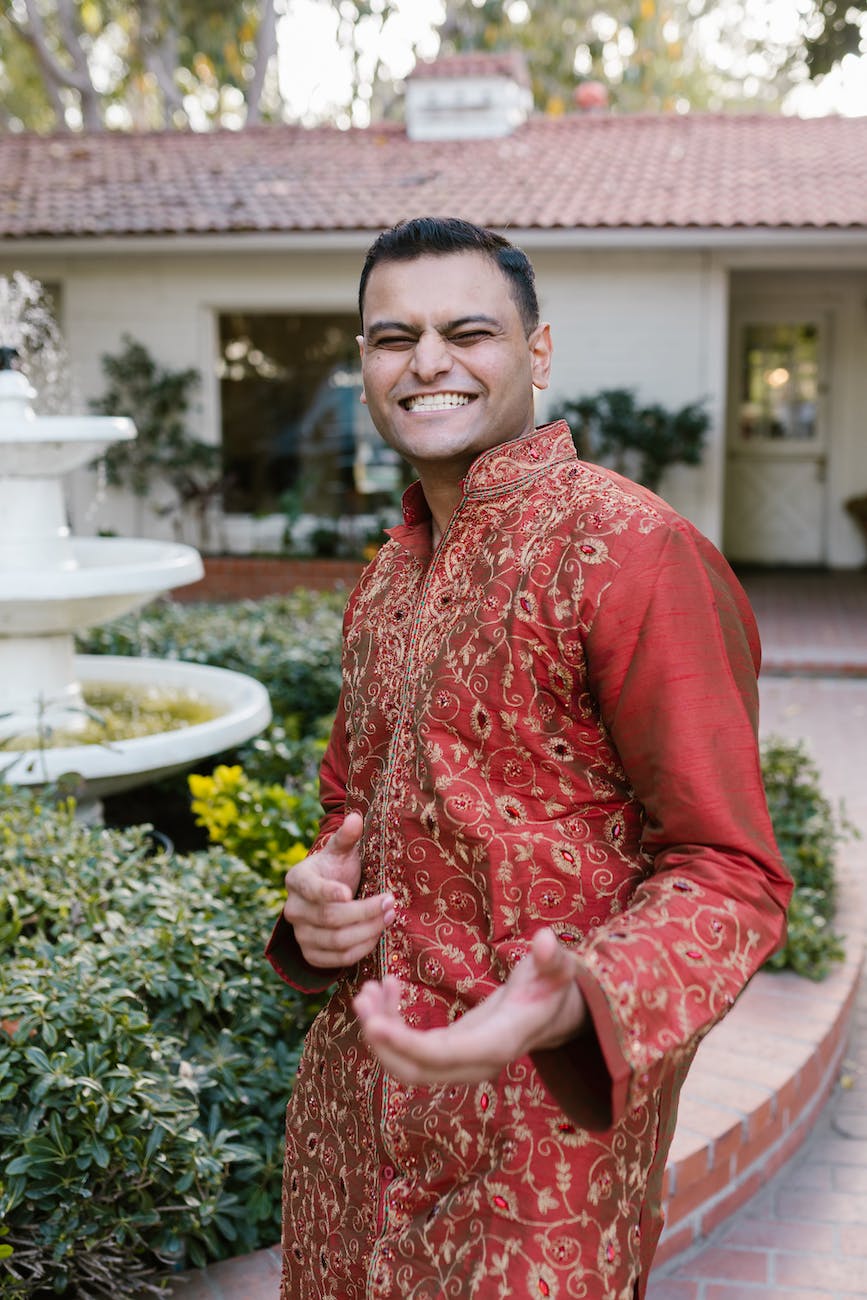 smiling man wearing a red traditional clothes posing