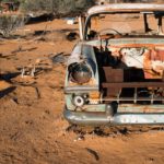 rusty car abandoned in desert