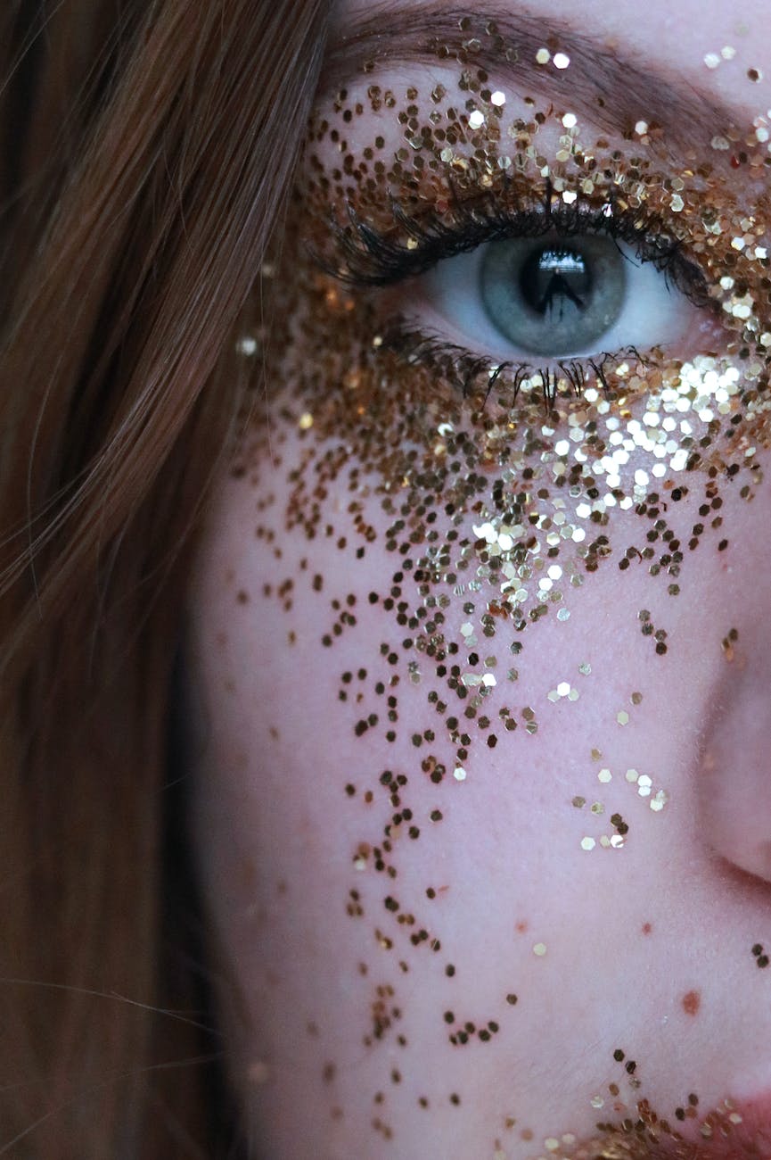 close up photo of woman with gold glitters on her face