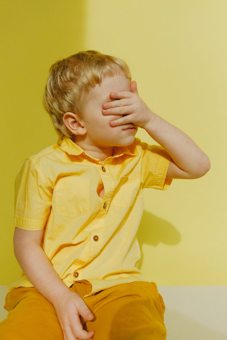 photo of a boy covering his eyes