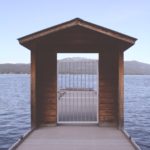 brown wooden dock with white metal fence