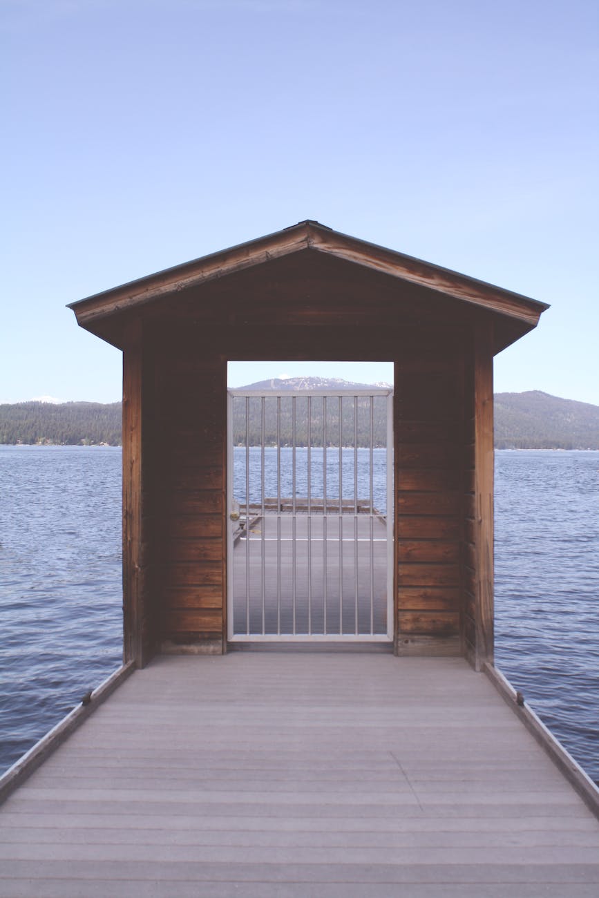 brown wooden dock with white metal fence